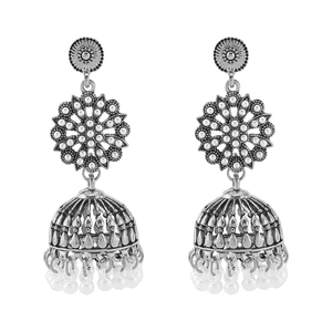 Detail of vintage silver Jhumka earrings with ethnic floral patterns and white bead tassels
