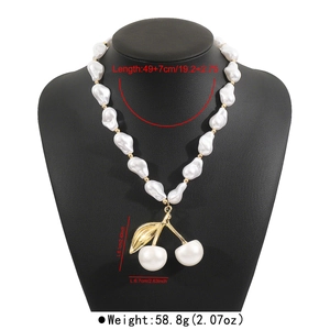 Vue détaillée du collier en perles baroques avec pendentif cerise sur buste noir