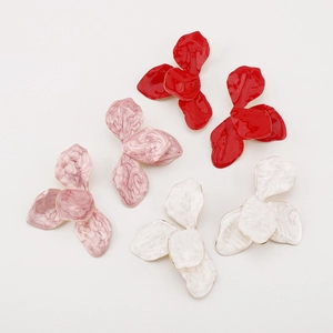 Detailed macro view of three-petal flower stud earrings in red, pink, and white marble textures