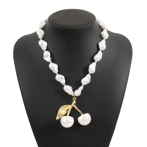 Détail du collier de perles baroques avec pendentif cerise sur buste noir