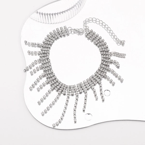 Dettaglio macro della collana con nappine argentate e strass su specchio