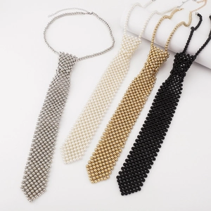 Détail de colliers cravate en perles tissées en argent, blanc, or et noir avec chaînettes