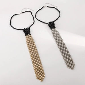 Détail de colliers cravate perlés aux finitions noir, doré et argenté poli