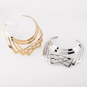 Macro detail of layered gold and silver geometric choker necklaces with a high-shine finish