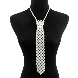 Détail du collier cravate en fausses perles sur un buste noir avec fond blanc pur