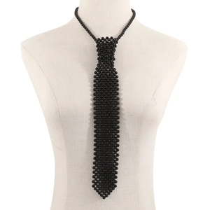 Détail d'une cravate artisanale en perles noires présentée sur un mannequin de vitrine