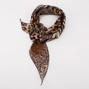 Macro detail of silk scarf showing animal print tied into a decorative floral shape