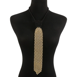 Gros plan détaillé d'un collier en perles style cravate avec motif damier noir et doré