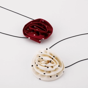Detailed macro view of satin polka dot rose fabric choker necklaces with thin black ribbons