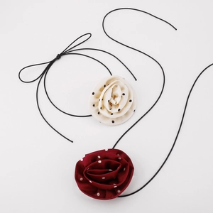 Macro detail of satin polka dot rose fabric choker showing delicate petal textures