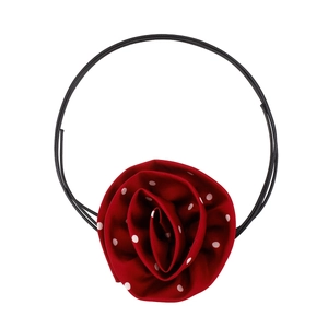 Detailed close-up of a red satin rose choker with white polka dots and long black ribbons