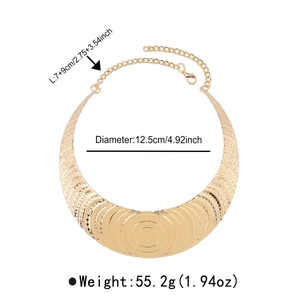 Detail of gold metal choker with intricate concentric texture and lobster clasp