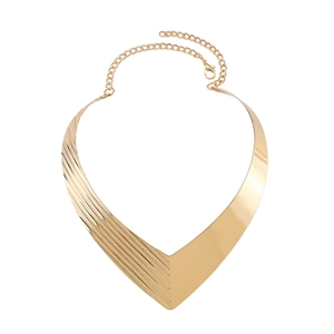 Macro shot of gold V-shaped metal choker showing striped texture and polished finish