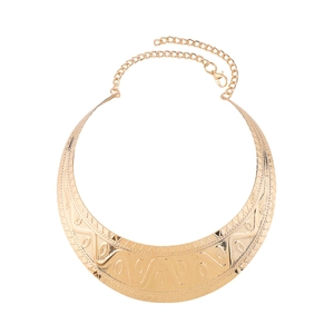 Detailed close-up of golden collar necklace with embossed tribal patterns and lobster clasp
