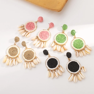 Detailed macro view of woven raffia shell earrings in pink, green, khaki, and black colors