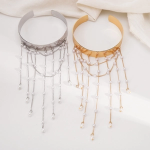 Λεπτομερής προβολή boho μεταλλικών περιβραχιόνιων με κομψές φούντες από μαργαριτάρια