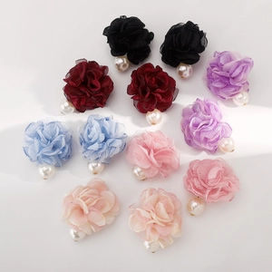 Detalle de pendientes de camelia de tela hechos a mano con perlas en seis colores