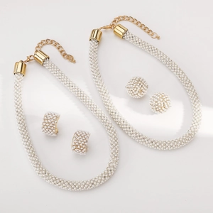 Detailansicht eines eleganten Perlen-Schmucksets mit goldfarbenen Halsketten und Ohrringen