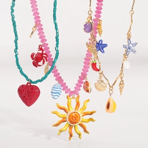 Dettaglio di gioielli boho con perline e ciondoli marini colorati come stelle e conchiglie