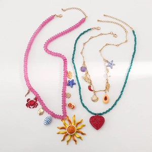 Dettaglio delle collane di perline colorate con pendenti marini come stelle e conchiglie