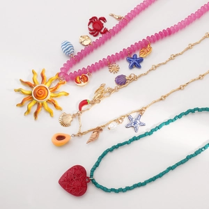 Dettaglio di collane oceano boho con perline colorate, conchiglie e pendenti a cuore