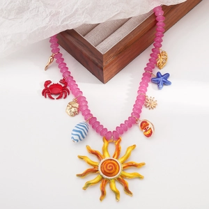 Dettaglio della collana boho con perline colorate, sole arancione e ciondoli marini