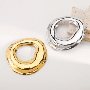 Macro detail of irregular geometric brooch showing gold and silver textured metal finishes