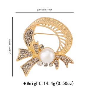 Sparkling crystal wreath brooch with white pearl and bow detail, sized 4.8cm by 4.5cm