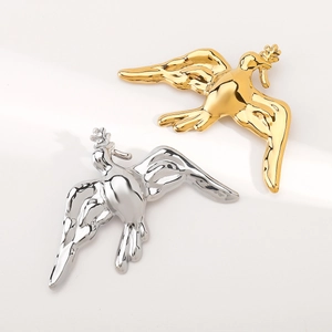 Detailed view of polished vintage peace dove brooches in gold and silver finish