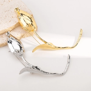 Detail view of gold and silver tulip bud brooches with high-polished mirror finish