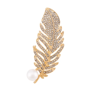 Detailed close-up of golden feather brooch with crystal pave and large white pearl