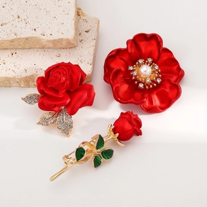 Élégante broche fleur rose rouge avec perles et cristaux sur un socle en pierre