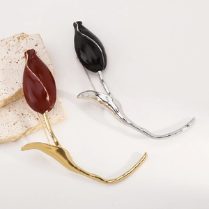 Detailed macro view of red and black enamel tulip brooches with elegant gold and silver finish