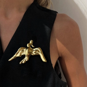 Vintage luxury gold dove brooch in polished stainless steel on a black elegant top