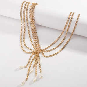 Detailed macro view of bohemian multi-layer gold chain body jewelry with white pearl pendants