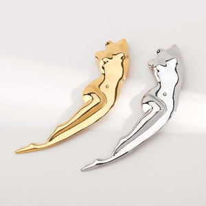 Close-up of gold and silver polished stainless steel female body sculptures lapel pins