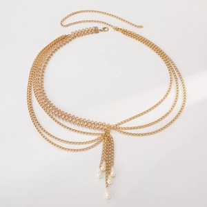 Detail view of a layered gold metal waist chain with pearl charms and lobster clasp closure