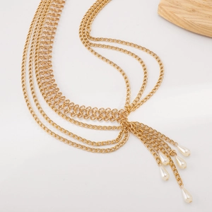 Detail of bohemian gold layered body chain with elegant white pearl droplets decor