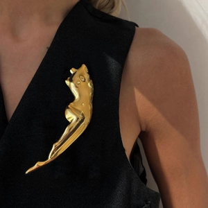 Artistic gold-plated feminine sculpture brooch on elegant black vest for a luxury fashion look