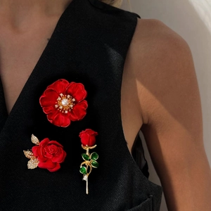Élégant ensemble de 3 broches roses rouges avec perles et diamants sur un gilet noir
