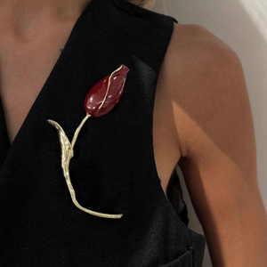 Elegant tulip brooch with red enamel and gold lava texture on a black vest