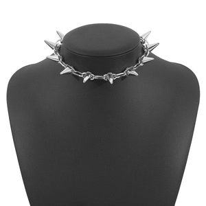 Dettaglio della collana punk con borchie argentate su un busto nero opaco