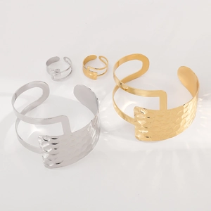 Dettaglio dei bracciali regolabili martellati oro e argento con anelli coordinati