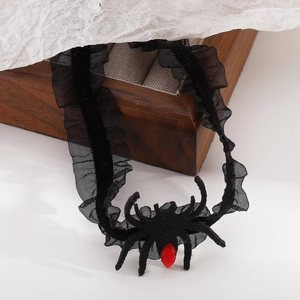 Detailansicht eines schwarzen Spitzen-Chokers mit Samtspinne und rotem Tropfen-Edelstein