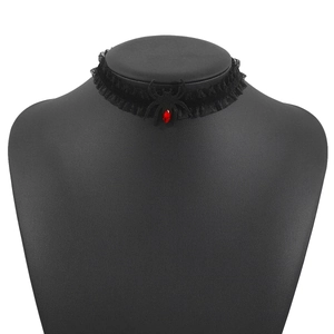Makro-Detail des gotischen schwarzen Spitzen-Chokers mit Spinnen-Anhänger und rotem Edelstein