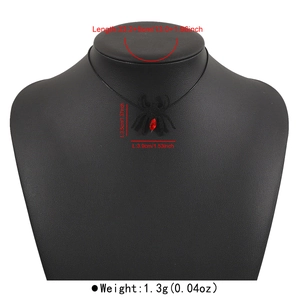 Makroaufnahme von schwarzem Spinnenanhänger mit rotem Strass und Gothic Choker