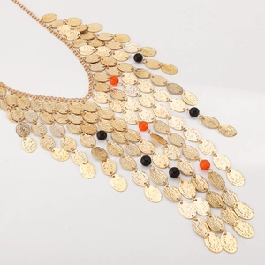 Dettaglio di collana boho dorata a più strati con paillettes martellate e perline colorate