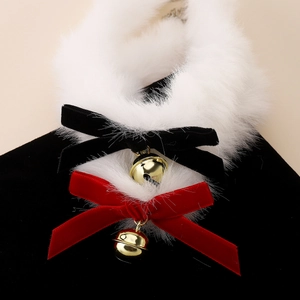 Détail d'un collier en peluche blanche avec des nœuds en velours et cloches dorées