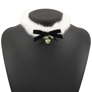 Détail d'un choker en fausse fourrure blanche avec nœud en velours noir et grelot doré