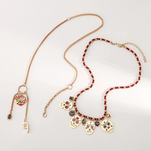 Detail van rode kralenketting met kleurrijke schedelhangers en gouden hartvormige hanger